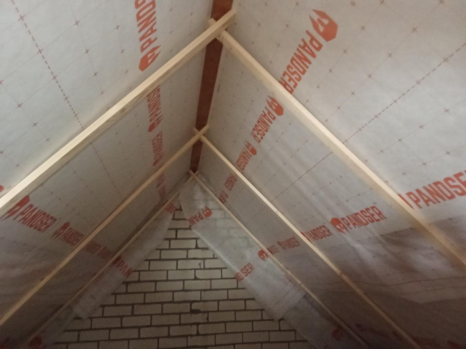 Dezelfde zolder na het isoleren, met folie en houten latten tegen het dak