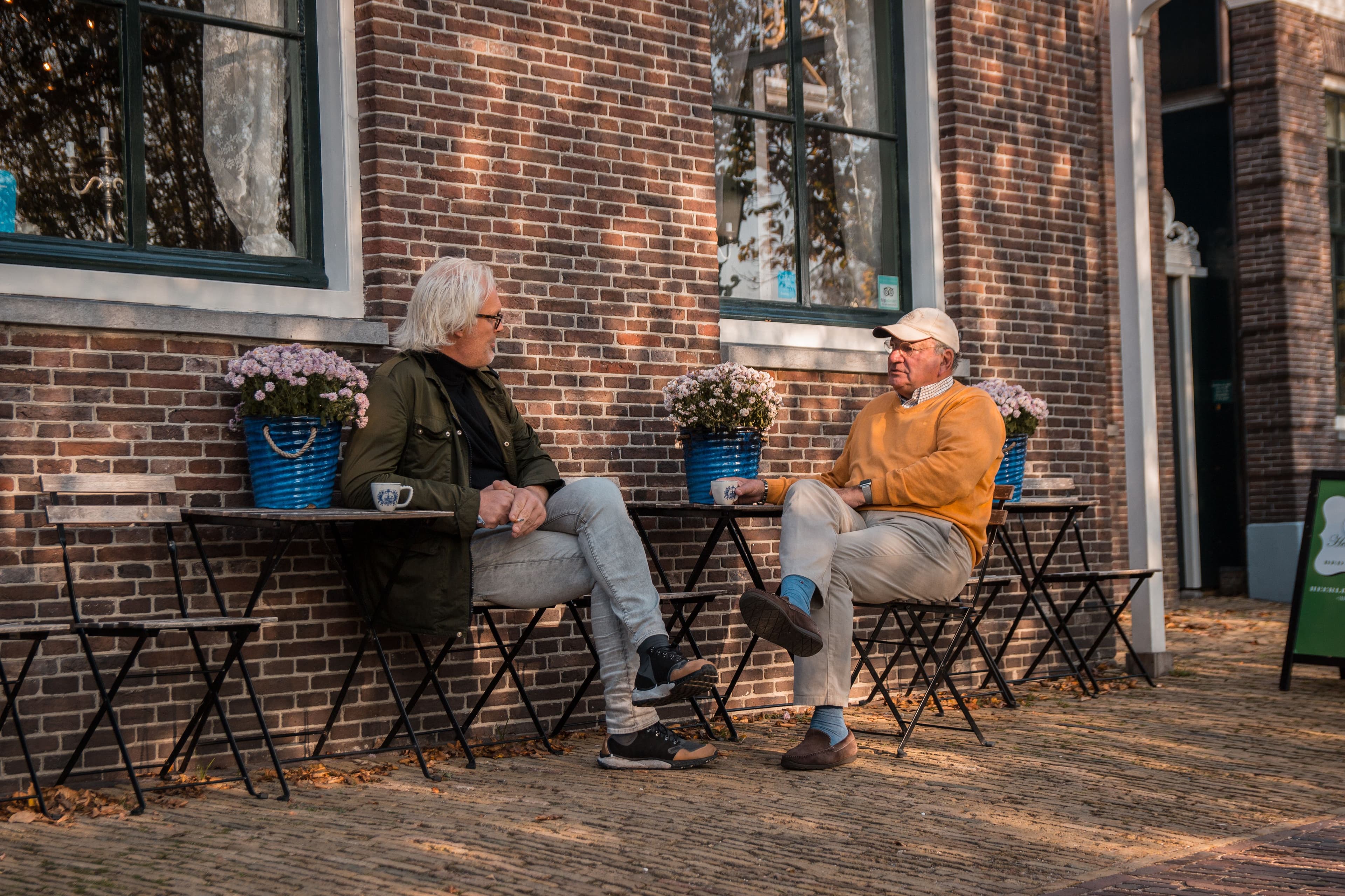 Twee mannen in gesprek op straat bij een Nederlandse woning